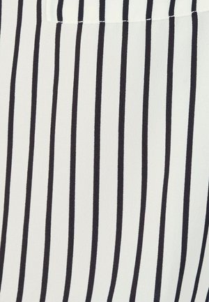 Weißer Stoff mit gleichmäßig verteilten dünnen vertikalen schwarzen Streifen und einem eingenähten rechteckigen Flicken nahe der oberen Mitte.