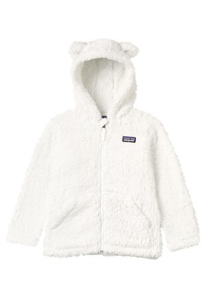 Hvit fleece-lue med bjørneører, glidelås foran, to frontlommer og et logomerke. Har en myk tekstur og fluffy stoff.