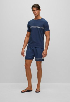 Mörkblå kortärmad skjorta för herrar med matchande shorts som har texten "BOSS" i kontrasterande vitt. Slätt tyg och avslappnad passform.