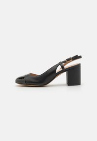 Sorte skinn slingback-pumps med rund tå, blanke tåhette og en chunky blokkhel. Justerbar stropp med gulltonet spenne.