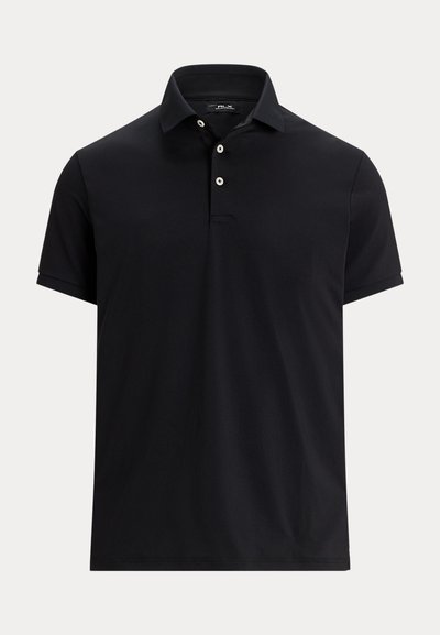 Svart kortärmad polo med tre vita knappar och klassisk krage på en enfärgad ljus bakgrund.