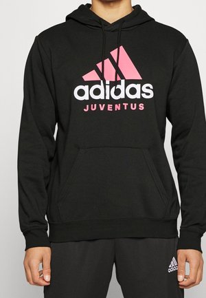 Sweatshirt à capuche noir en tissu doux, présentant un grand logo Adidas rose et blanc avec le mot "JUVENTUS" en dessous. Poche avant visible.