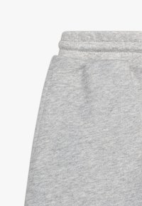 Szare spodnie dresowe z miękkiego, teksturowanego materiału. Posiadają elastyczny pas i prosty krój, odpowiednie do noszenia na co dzień.