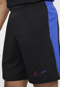 Sorte atletiske shorts med en blå sidepanel, lavet af letvægtsmateriale, med en lille broderet rød og blå Nike-logo.