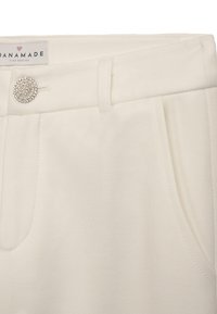 Weiße Baumwollmischhosen mit glatter Textur, einem flachen Bund, seitlichen Taschen und einem dekorativen Strassknopf als Akzent.