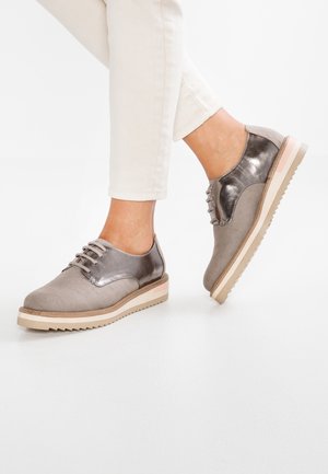 Oxfords grises y metálicos con un upper texturizado, detalles de cordones y una suela de goma contrastante con acentos en beige y rosa.