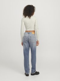 Lys grå langermet crop topp, kombinert med lys blå rette jeans med lommepotter og lærdetaljer. Svart fottøy.