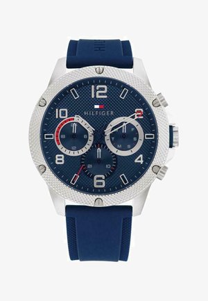 Blaues Gummiband-Uhr mit einem Gehäuse aus Edelstahl in Silber, strukturiertem blauen Zifferblatt, großen arabischen Ziffern, drei Zusatzanzeigen und roten Akzenten.