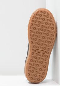 Sneaker nera con superficie testurizzata e suola in gomma naturale caratterizzata da un motivo geometrico. Logo prominente sul tallone.