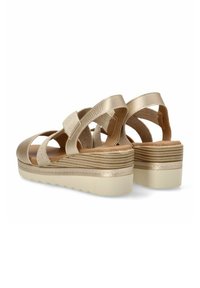Sandalias de cuña beige con tiras texturizadas, plantilla acolchada y suela acanalada, mostradas desde un ángulo trasero sobre un fondo blanco.