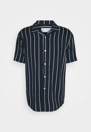 Camisa de manga corta azul marino con rayas verticales blancas, cierre de botones, cuello campestre y dobladillo redondeado. Hecha de tela ligera.