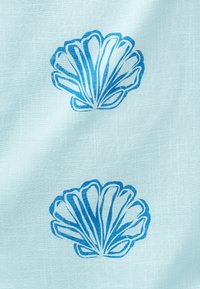 Ανοιχτό μπλε ύφασμα με δύο ομοιόμορφα τοποθετημένα μοτίβα σκοτεινών μπλε κοχυλιών, με φόντο υφή υφάσματος.