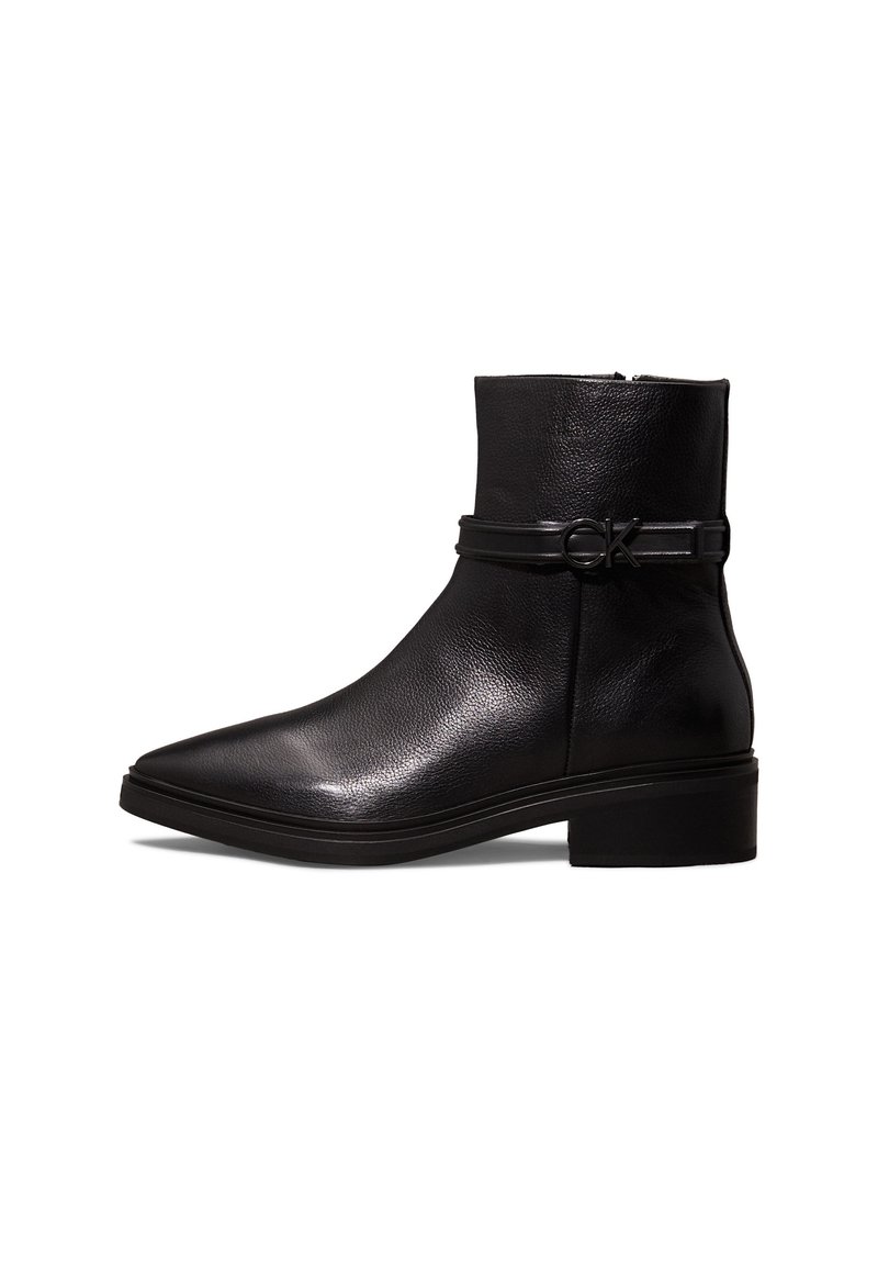 Bottine en cuir noir avec talon bloc bas, bout pointu et une bride latérale ornée d'une petite boucle avec le logo "CK".