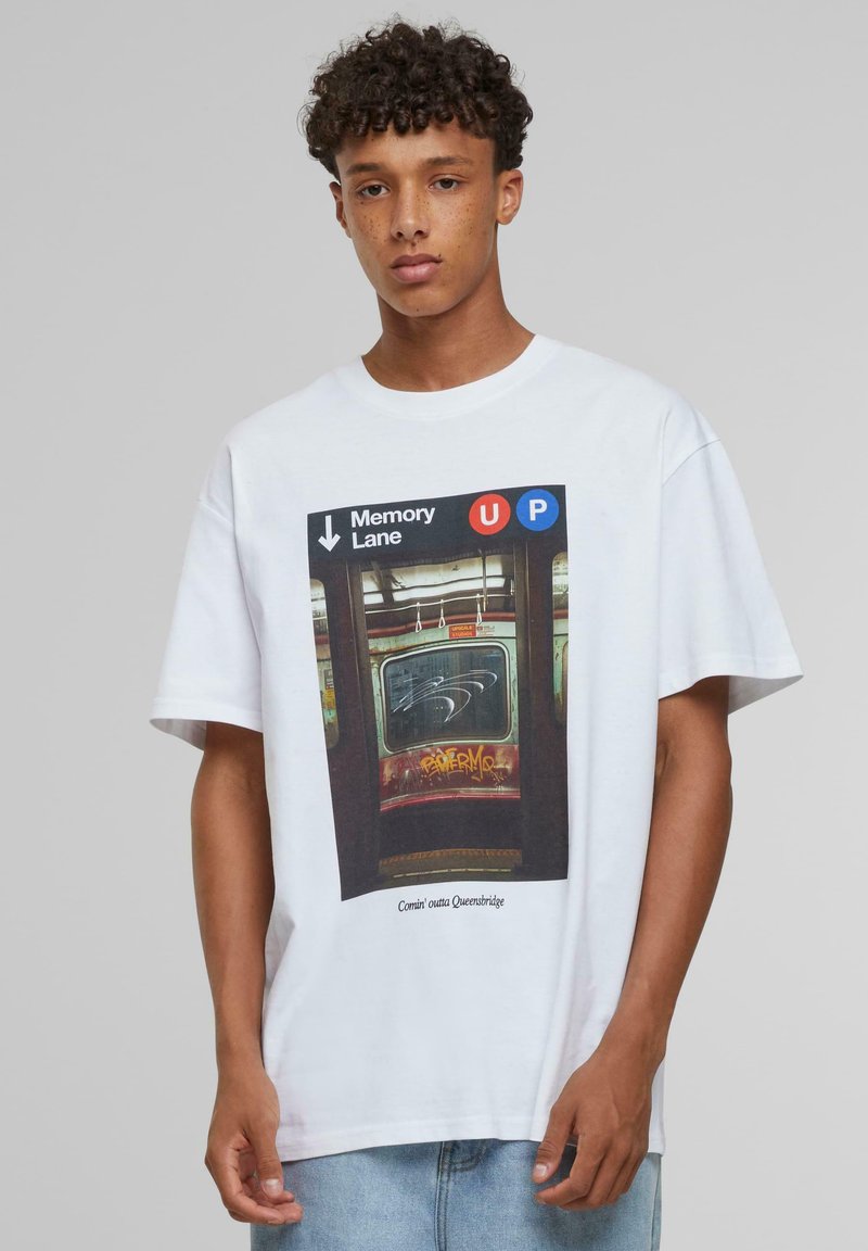 Hvid t-shirt med et grafisk motiv af en subway-dør med teksten "Memory Lane" og "UP", der fremhæver klare farver og en struktureret baggrund.
