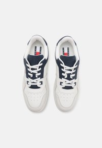 Sneaker bianche e blu navy con tomaia in materiale sintetico, dettagli in rete, punta perforata, lacci piatti e insole con logo. Accentuate con cuciture a contrasto.