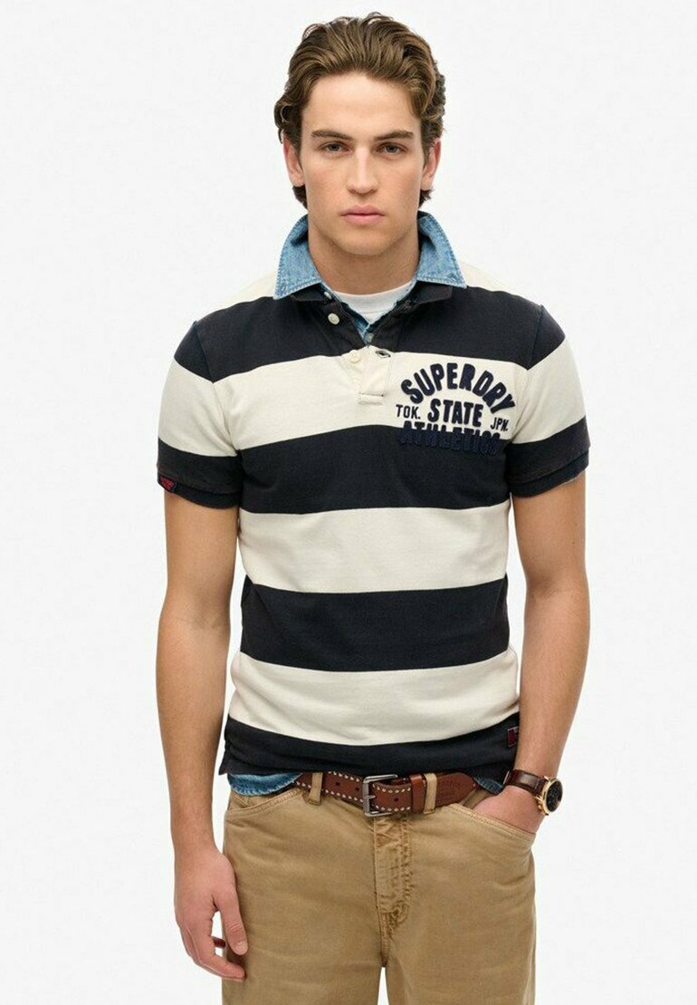 Gestreepte polo in marineblauw en wit, met een denim kraag. Draagt met kaki broek en een bruine riem. Casual ontwerp met logo-details.