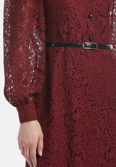 Burgunderfarbenes Spitzenkleid mit Blumenmustern, langen Puffärmeln und schwarzem Lackgürtel. Verfügt über Knöpfe zum Schließen und strukturierten Spitzenstoff.