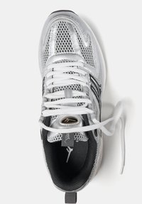 Silver färgad sportig sneaker med mesh och syntetiska överdrag, vita snören, svart inredning och en logotypdetalj på tungan.