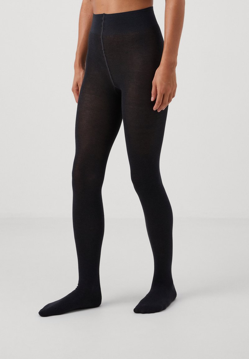 Svarta ogenomskinliga leggings med en texturerad yta och bred midja, med en sömlös design och en åtsittande form som sträcker sig ner till anklarna.