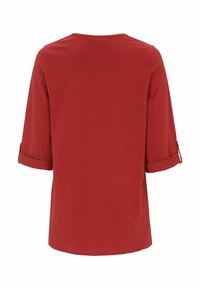 Röd kortärmad skjorta med rund halsringning och uppvikta ärmar. Tillverkad av mjukt tyg, med en slät yta och enkel design.
