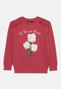 Felpa rossa con polsini e colletto a coste, caratterizzata da un design floreale con rose bianche e il testo "la Vie en Rose". Spalle arricciate.