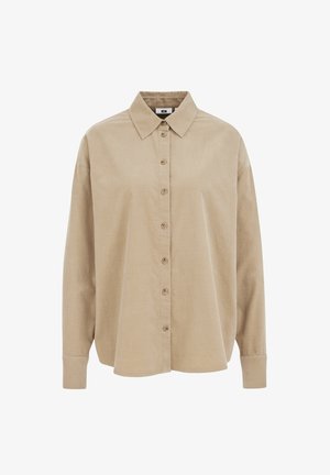 Bežs garām piedurknēm pogājams krekls ar punktveida apkakli un aprocēm, izgatavots no mīksta kordūru auduma.