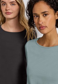 Dos camisetas de manga corta: una gris oscuro y una verde agua clara. Ambas tienen un cuello redondo y una textura suave y lisa.