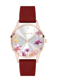 Rosaguld ur med en sølvskive med blomsterdesign, der har et rødt silikonerem. Skiven viser timer fra 1-12 markeret i guld.