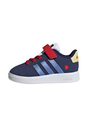 Granatowy sneaker Adidas z jasnoniebieskimi paskami, czerwonymi sznurowadłami i paskiem, białą podeszwą oraz żółtą łatką na pięcie z czerwonym detalem logo.