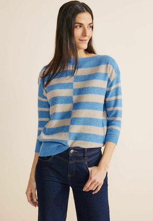 Gestreifter Pullover in Blau und Beige aus weichem Strick, mit einem Bootsausschnitt und Dreiviertelärmeln, kombiniert mit dunklen Jeans.
