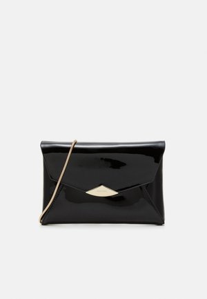 Pochette enveloppe noire brillante avec un fermoir triangulaire doré et une fine chaîne dorée sur un fond uni.