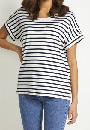 T-shirt rayé en blanc et bleu marine, à manches courtes, col rond, en tissu doux, associé à un jean bleu clair.