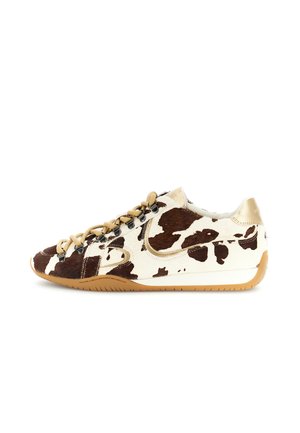 Sneaker basso con motivo in pelle di mucca marrone e bianca, lacci color cuoio e suola in gomma, mostrato di profilo su sfondo bianco.