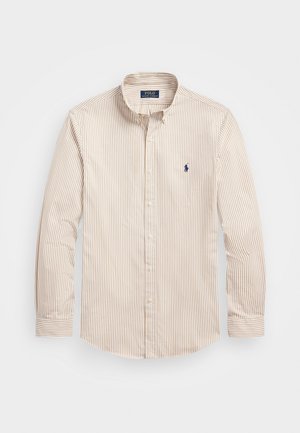 Beige-weiß gestreiftes Hemd mit langen Ärmeln, Knopfleiste und Kragen, mit einem kleinen dunkelblauen, gestickten Logo auf der Brust.