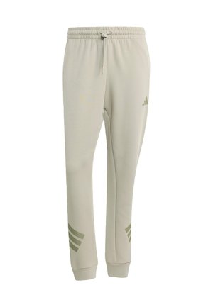 Lichtgrijze joggingbroek met elastische tailleband en trekkoord. Voorzien van een groen Adidas-logo en het ontwerp met drie strepen op de enkels.