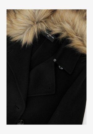 Čierny vlnený kabát s umelou kožušinou na golieri, s usporiadanými klopami a gombíkovým zapínaním. Hladký povrch s minimálnymi viditeľnými švami.