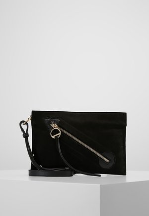 Bolso clutch rectangular negro con cremallera diagonal dorada y pulsera de cuero, exhibido sobre pedestal blanco contra fondo gris.