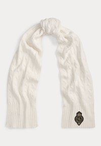 Scarf bianco a maglia cable-knit con una texture morbida. Presenta un bordo a coste e una patch logo nera con accenti dorati. Legato al centro.