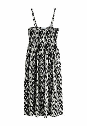 Maxikleid in Schwarz-Weiß mit Smok-Einsatz und dünnen, verstellbaren Trägern, versehen mit einem auffälligen Ikat-Muster und einem fließenden Rockdesign.