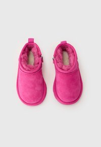 Botines forrados de lana rosa con un exterior de ante suave, punta redondeada y cremallera lateral para facilitar el uso. Tejido texturizado con un interior suave.