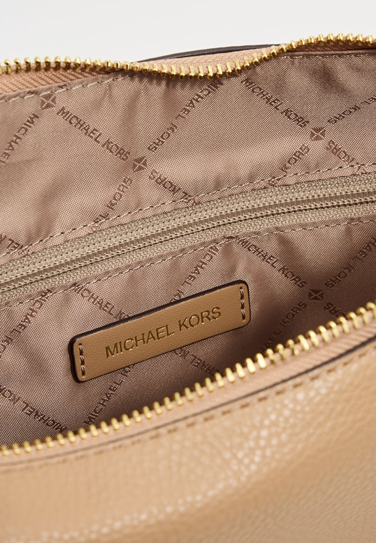 Bolsita de piel marrón con cierre de cremallera dorada. El interior cuenta con un forro de tela marrón con un sutil patrón de logo y un bolsillo con cremallera. Etiqueta de logo dorada visible.