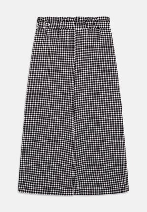 Pantalon large à motif vichy noir et blanc avec taille élastique froncée, posé à plat sur un fond blanc.