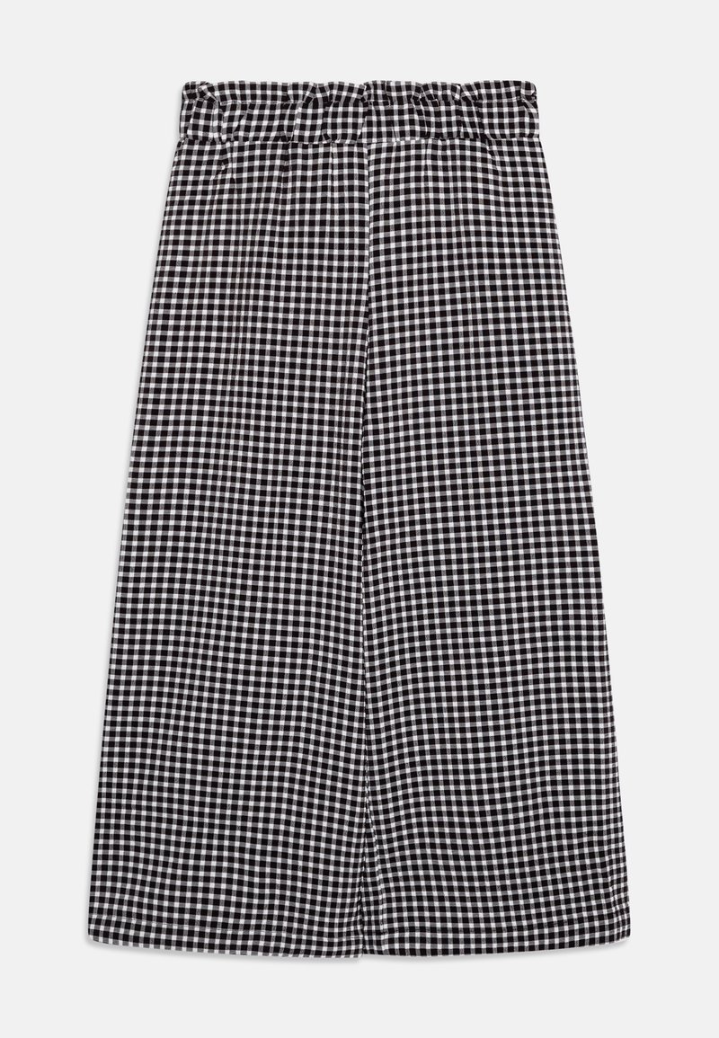 Pantalon large à motif vichy noir et blanc avec taille élastique froncée, posé à plat sur un fond blanc.