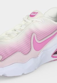 Λευκό και ροζ αθλητικό παπούτσι Nike Air Max με mesh επάνω μέρος, ροζ σχέδιο πλέγματος, ροζ λογότυπο Swoosh και ορατό αεριζόμενο μαξιλάρι στη σόλα.