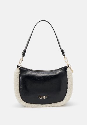 Sac à bandoulière Guess noir avec bord en fausse fourrure blanche, logo et accessoires dorés, et une seule sangle noire réglable, présenté sur fond uni.