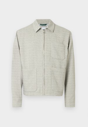 Chaqueta gris claro con cremallera, en tejido texturizado, con cuello de punta, dos bolsillos frontales y mangas largas de corte recto.