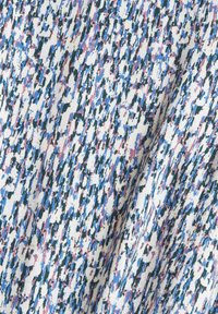 Tissu léger présentant un motif texturé de taches bleues, roses et vertes sur un fond blanc, créant un aspect visuellement dynamique.