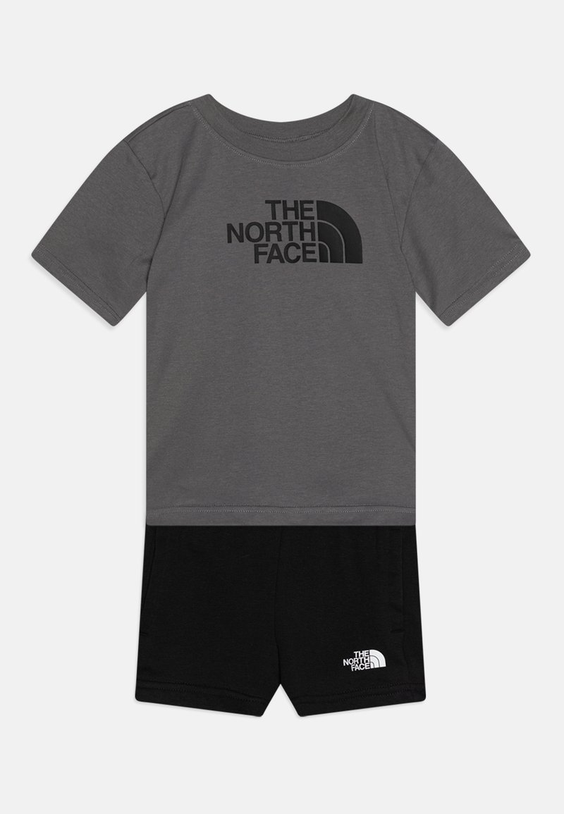 Grå t-shirt med kort ärm och svart "The North Face"-logotyp, matchat med svarta shorts med vit logodetalj på kanten. Mjuk tyg.