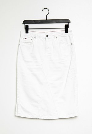 White knee-length denim skirt with front pockets and button, hanging on black hanger against white background.