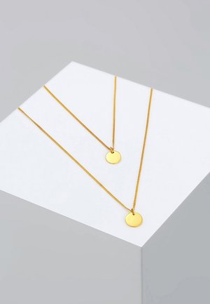 Goldfarbene, geschichtete Halsketten bestehen aus zwei dünnen Ketten mit runden Anhängern. Die Anhänger sind glatt und glänzend und schaffen ein minimalistisches Design.
